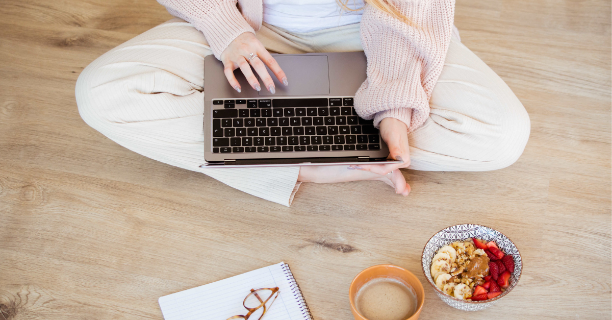 Woman with computer, glasses, mushroom coffee, bowl of granola and fruit