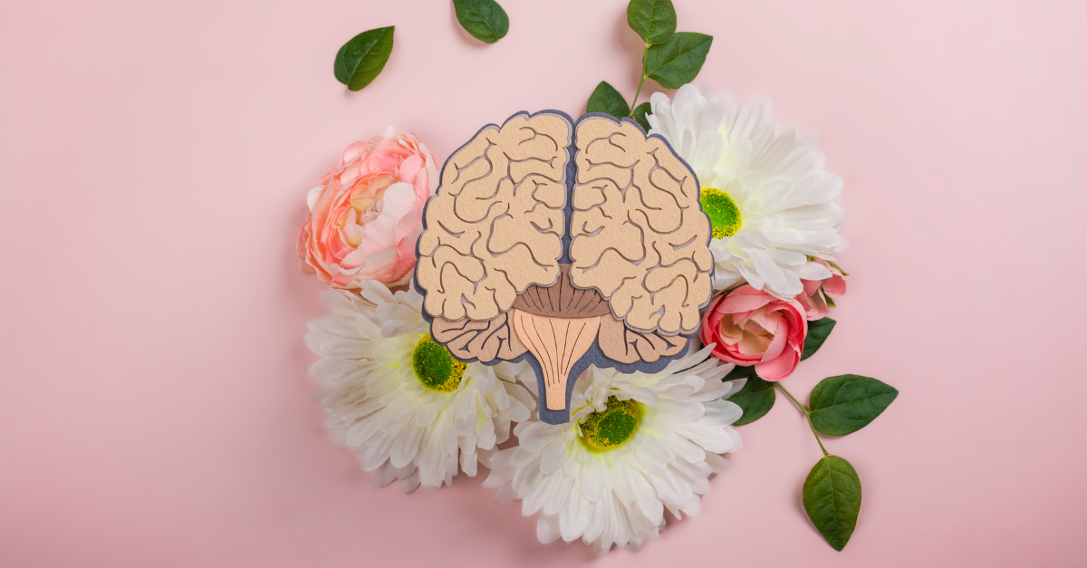 An image of a brain sits on a bouquet of flowers with a pink background